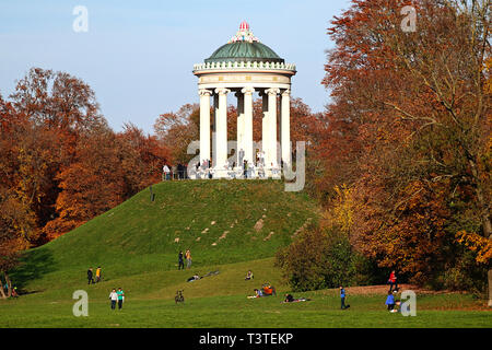 People enjoy a beautiful autumnal day full of sun near the Monopteros at the Englischer Garten in Munich Stock Photo