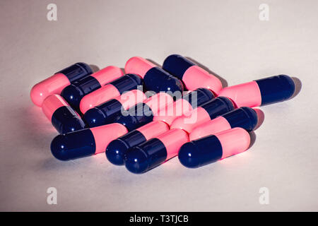 Close up of pink and blue Amoxicillin antibiotics capsule pills. Concept for Antimicrobial drug resistance; pharmaceutical industry; Global healthcare Stock Photo