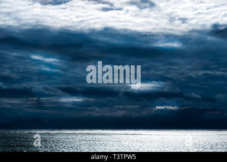 Dark storm clouds forming above the calm waves of the Atlantic Ocean, Block Island, RI Stock Photo