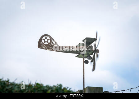 Weather vane in form of an old rusty biplane at a side-view close-up, with propellers moving Stock Photo