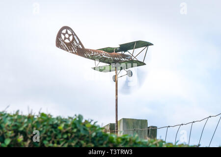 Weather vane in form of an old rusty biplane at a 3-4 view close-up, with propellers moving fast Stock Photo