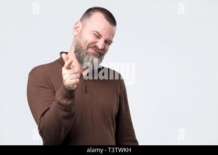 Cheerful bearded man in casual clothes indicates happily at you Stock Photo