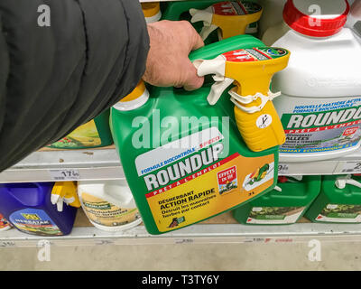 Paris, France - January 25, 2019: Customer buying roundup in a french Hypermarket. Roundup is a brand-name of an herbicide containing glyphosate, made Stock Photo