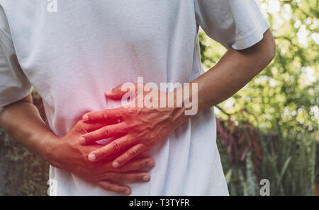 Male suffering from stomachache pain. A man stomachache at outdoor,Healthy concept. Stock Photo