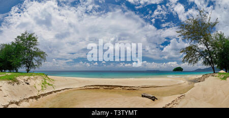 Panoramic photo of a fragment of the coast and the ocean, Tioman island, under blue sky with white clouds. Stock Photo