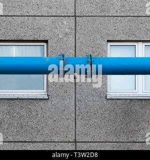 The blue water pipe in front of the windows of the prefabricated house Stock Photo