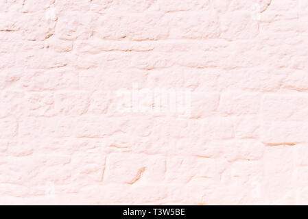 stone wall painted completely white, in the sun, ideal to use as a background for its smooth texture. Stock Photo
