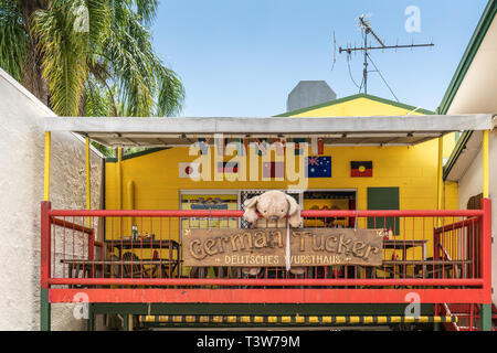 Cairns, Australia - February 18, 2019: Closeup of yellow and red facade of German restaurant downtown Kuranda Village, selling bratwurst. Some green f Stock Photo