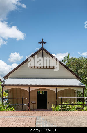 Cairns, Australia - February 18, 2019: Brown and beige Front facade and entrance to Saint Saviours Church under blue sky with white cloudscape downtow Stock Photo