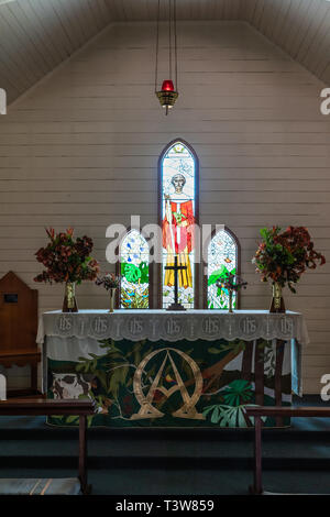 Cairns, Australia - February 18, 2019: Chancel of Saint Saviours Church in downtown Kuranda Village. Stained glass window and altar. Stock Photo