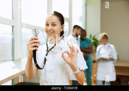 Healthcare people group. Professional female doctor posing at hospital office or clinic. Medical technology research institute and doctor staff service concept. Happy smiling models. Stock Photo