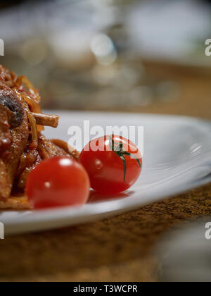 Small cuts of meat cooked along with fried mushrooms and onions are served to the table for dinner. Stock Photo