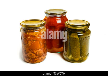 three glass jars on white background, pickled cucumbers, pickled tomatoes and canned meat Stock Photo