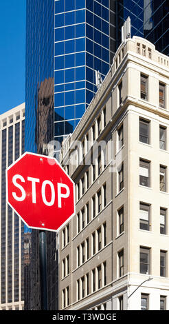 Stop sign on a street of New York City with buildings in background, selective focus, USA. Stock Photo