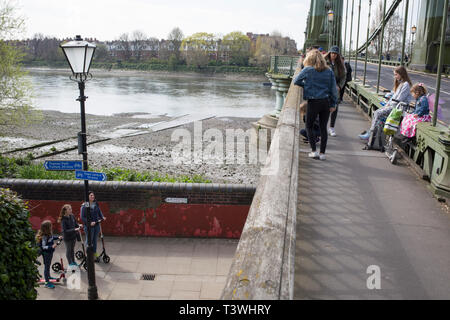 After being closed indefinitely to all traffic due to structural faults, pedestrians walk across Hammersmith Bridge, on 11th April 2019, in west London, England. Safety checks revealed 'critical faults' and Hammersmith and Fulham Council has said it's ben left with no choice but to shut the bridge until refurbishment costs could be met. The government has said that between 2015 and 2021 its is providing £11bn of support to the 132-year-old bridge. Stock Photo