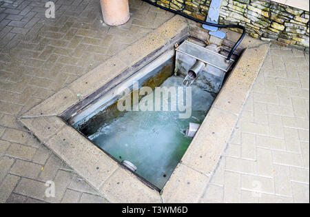 A small swimming pool with holy water from the spring. A niche in the floor for recruiting water from a source. Stock Photo