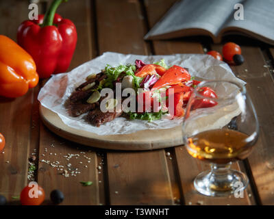 Fried beef pieces are served with garlic and red bell pepper. Stock Photo