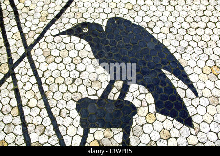 Detail of a cobble stone pavement design in Lisbon (Portugal) showing a raven and diagonal lines in black against the grey natural colour of the . Stock Photo