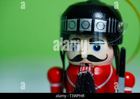 Close up of a nutcracker soldier on against a green and white background. Nutcracker soldier in hockey helmet Stock Photo