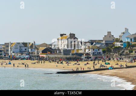 Lyme Regis, Dorset, UK.  12th April 2019. UK Weather.  Holidaymakers on the beach wrapped up warm to enjoy the spring sunshine at a chilly seaside resort of Lyme Regis in Dorset during the Easter school holidays.   Picture Credit: Graham Hunt/Alamy Live News Stock Photo