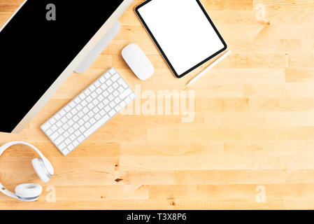 Desktop computer. Top view of wooden office desk with large desktop computer, keyboard, mouse, tablet, pen and headphone. All in one computer. Modern  Stock Photo