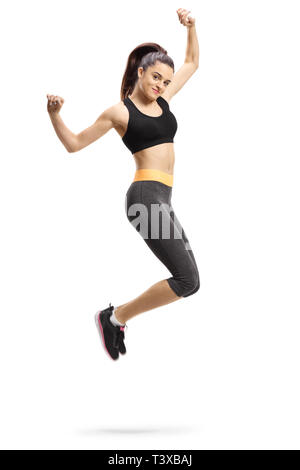 Full length shot of a happy young female in sportswear jumping isolated on white background Stock Photo