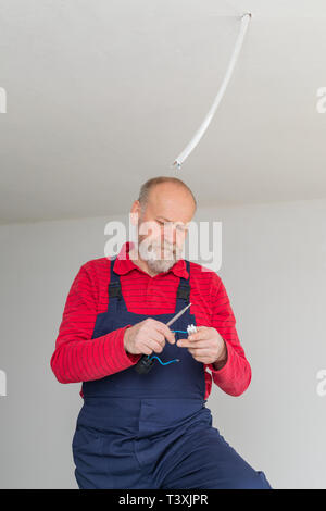 Close up picture of a senior electrician working in a new apartment - electric installation concept Stock Photo