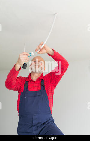 Close up picture of a senior electrician working in a new apartment - electric installation concept Stock Photo