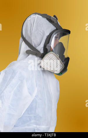 Side view of female worker in air pollution protection suit on yellow background. Stock Photo