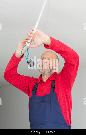 Close up picture of a senior electrician working in a new apartment - electric installation concept Stock Photo