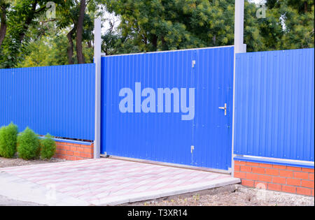 Fence and gate from sheets of blue corrugated metal Stock Photo - Alamy