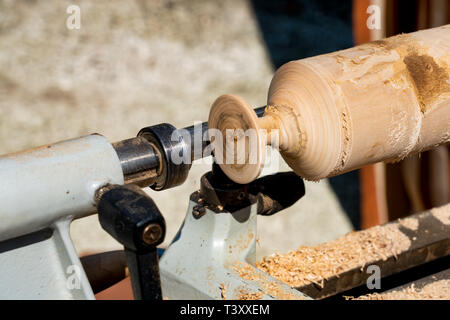 Carving a banister pillar in wood-turning lathe Stock Photo