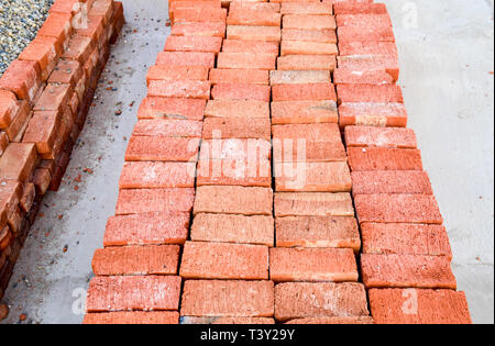 The red brick folded neatly on the foundation of the house. Home construction. Stock Photo