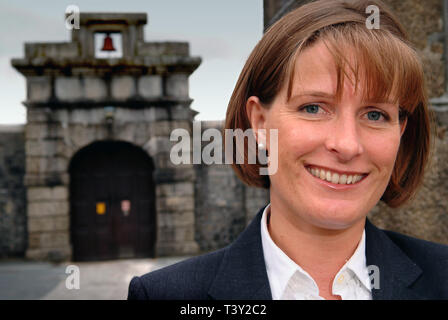 Claudia Sturt, former Governor of HM Prison Dartmoor, UK, outside the main entrance gate (bell over) inside and behind the main gate (barrred) Stock Photo