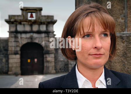 Claudia Sturt, former Governor of HM Prison Dartmoor, UK, outside the main entrance gate (bell over) inside and behind the main gate (barrred) Stock Photo