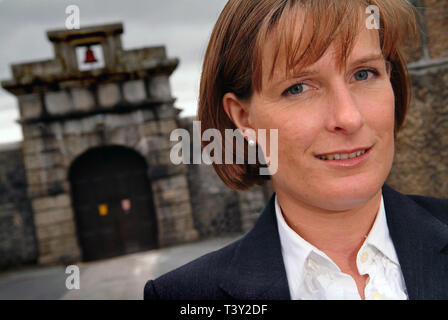 Claudia Sturt, former Governor of HM Prison Dartmoor, UK, outside the main entrance gate (bell over) inside and behind the main gate (barrred) Stock Photo