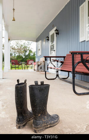 Dirty wellingtons on front porch Stock Photo