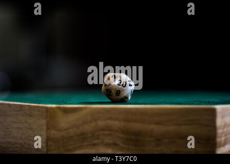 A d20 dice on top of a table (dice tray) showing the 20 side up. Stock Photo