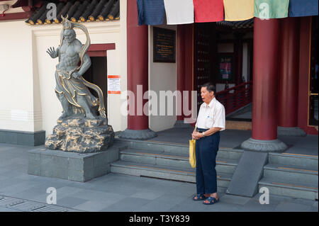 29.03.2019, Singapore, Republic of Singapore, Asia - A man is praying in front of the Buddha Tooth Relic Temple in Singapore's Chinatown district. Stock Photo