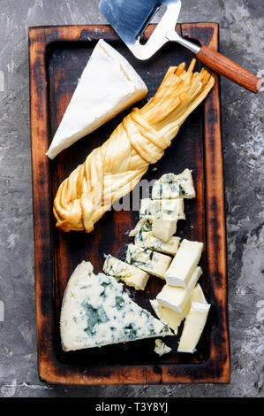 Cheese on dark slate on background.Different sorts of cheese.Various types of cheese Stock Photo