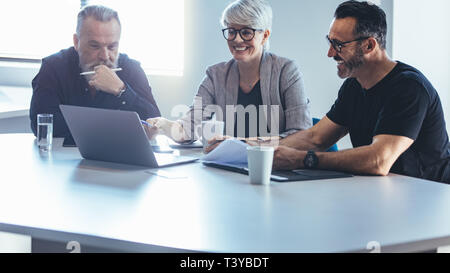 Business team meeting around a table in office. Group of business man and woman discussing work in office.