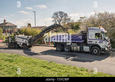 Presteigne, Powys, Wales, UK. A cold planer or milling machine removing the old road surface before new tarmac or asphalt is laid Stock Photo