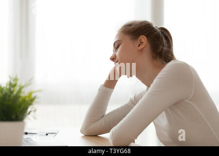 Tired exhausted woman sitting at desk falling asleep, working too long Stock Photo