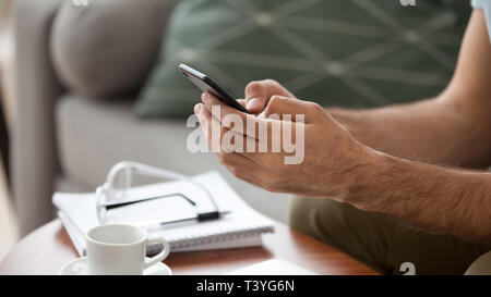 Close up man using, holding phone in hands, typing message Stock Photo
