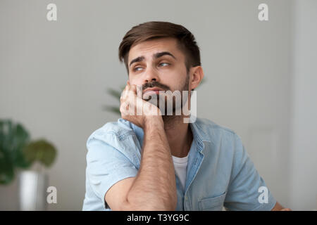 Tired bored man looking in distance, feeling lazy, lack motivation Stock Photo