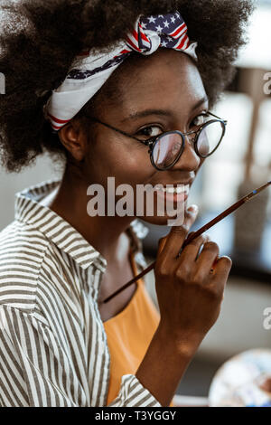 New project. Beaming dark-eyed African-American artist feeling excited before starting new project Stock Photo