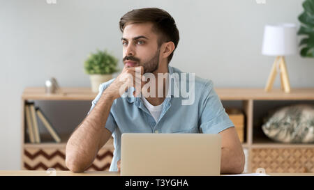 Thoughtful serious student or office worker thinking about online project Stock Photo