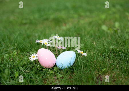 Easter hunt - two Easter eggs, ping and blue, in a grass Stock Photo
