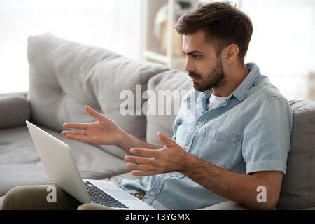 Shocked frustrated man looking at laptop screen, bad news receiving Stock Photo