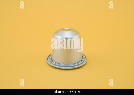Espresso coffee capsule or coffee pod on yellow background. Isolated. Stock Photo